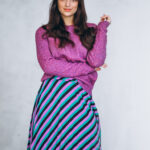 Beautiful woman in a purple sweater and skirt in studio